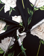 Black Italian Mulberry silk satin arranged in soft folds with large ivory roses and natural green leaves