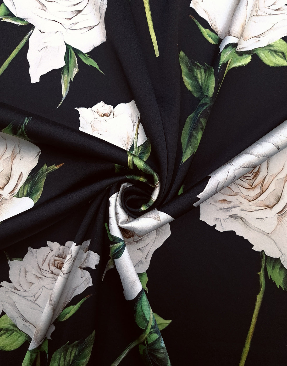 Black Italian Mulberry silk satin arranged in soft folds with large ivory roses and natural green leaves