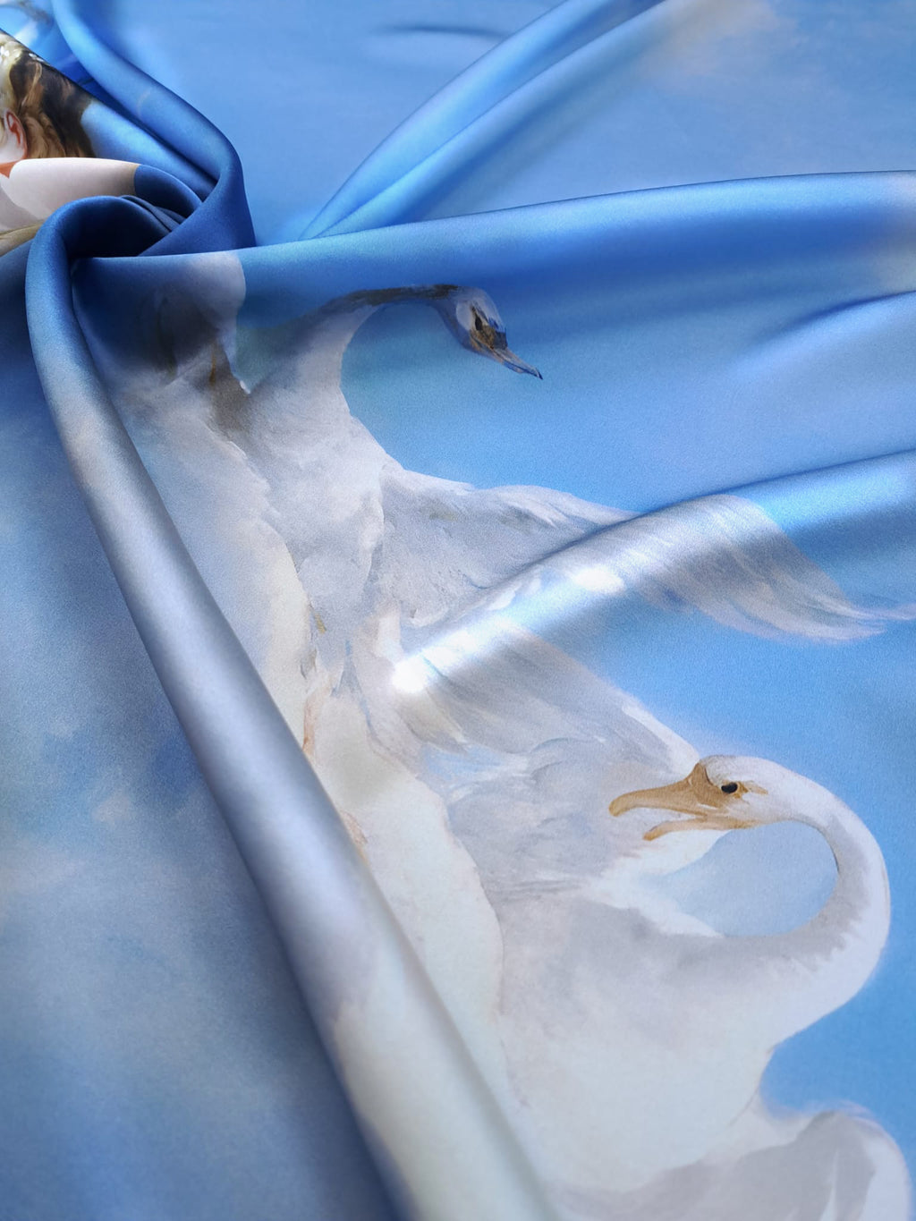 Draped blue mulberry silk satin with a luminous finish and elegant white swan print