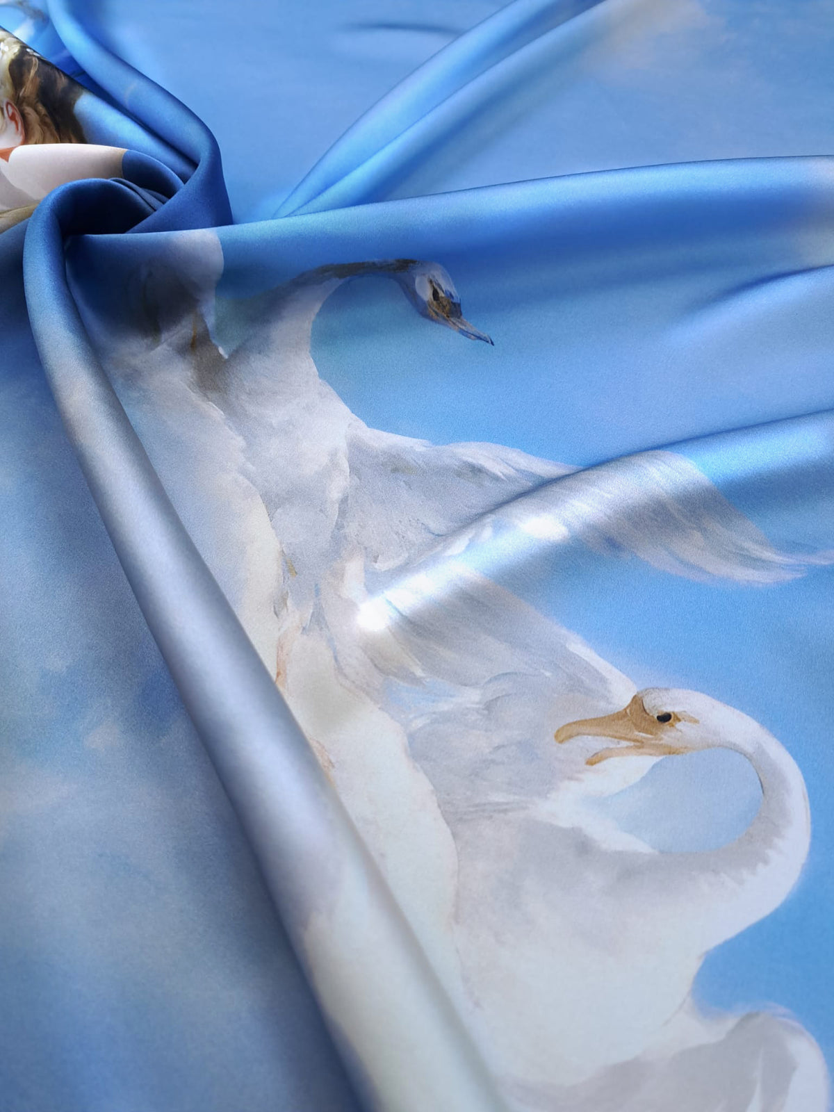 Draped blue mulberry silk satin with a luminous finish and elegant white swan print