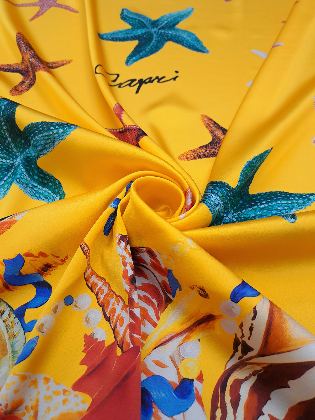 Colourful seashells, starfish, pearls and blue ribbons printed on yellow Italian silk satin.