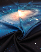 Natural silk satin fabric draped to show its smooth sheen and galaxy print in deep blue, black and luminous white