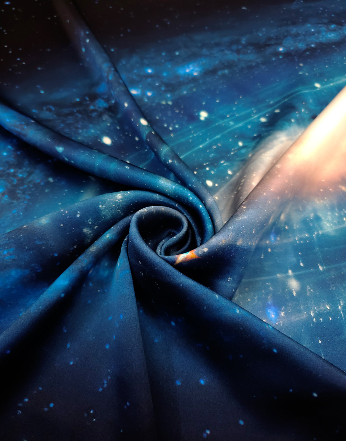Luxury natural silk satin fabric with a flowing drape and a deep blue galaxy and star print