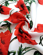 Italian silk satin printed with vivid red poppies and green stems on a white background.