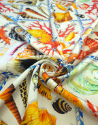 Italian printed silk satin featuring colourful seashells, starfish and vivid red coral within nautical rope frames.